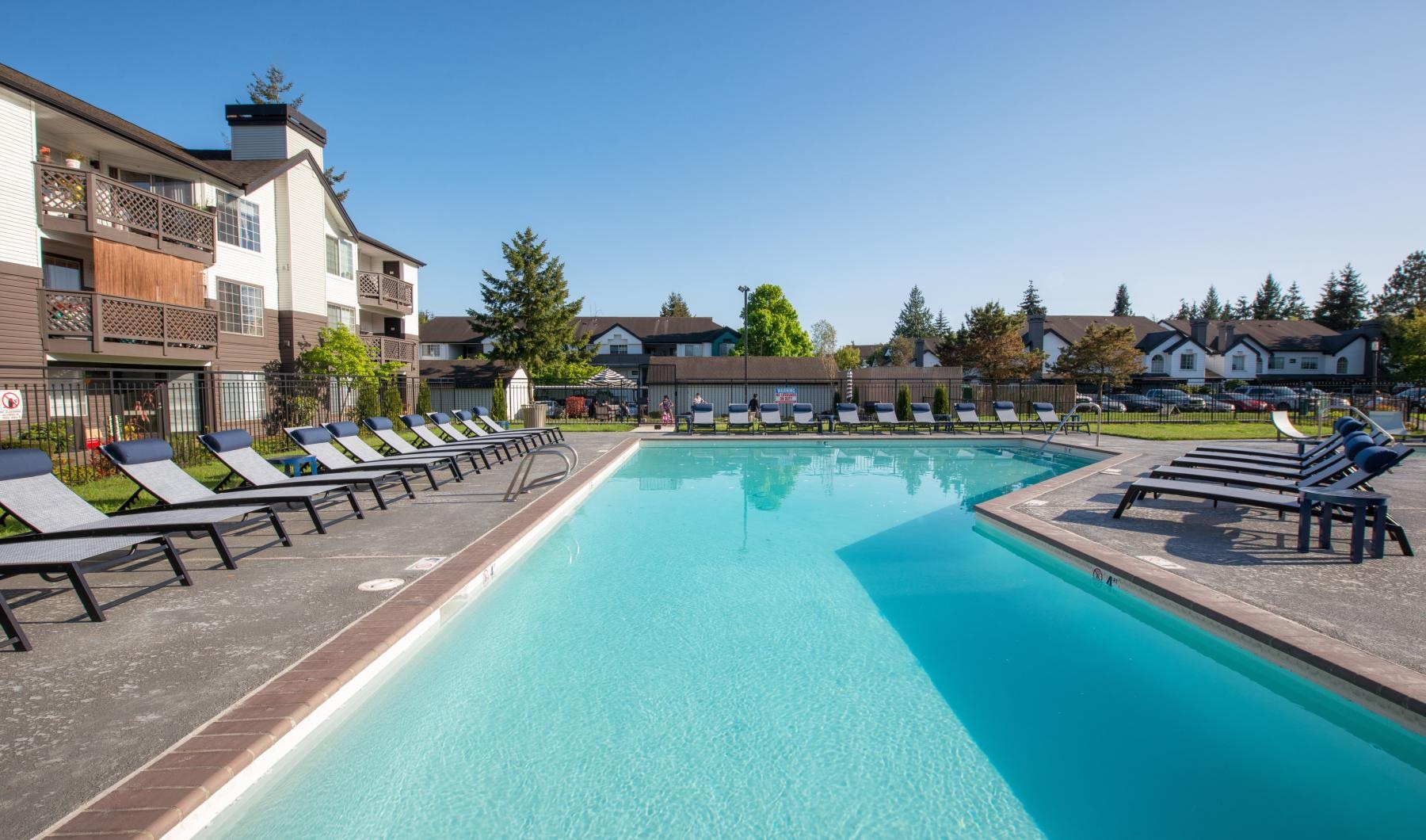 a swimming pool with lounge chairs around it