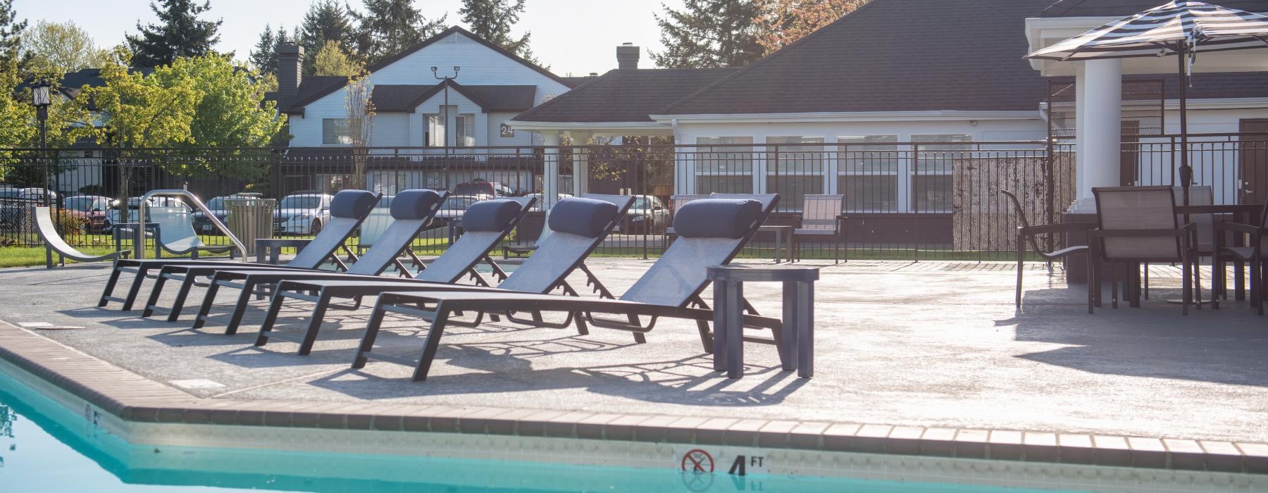 a pool with chairs and tables by it